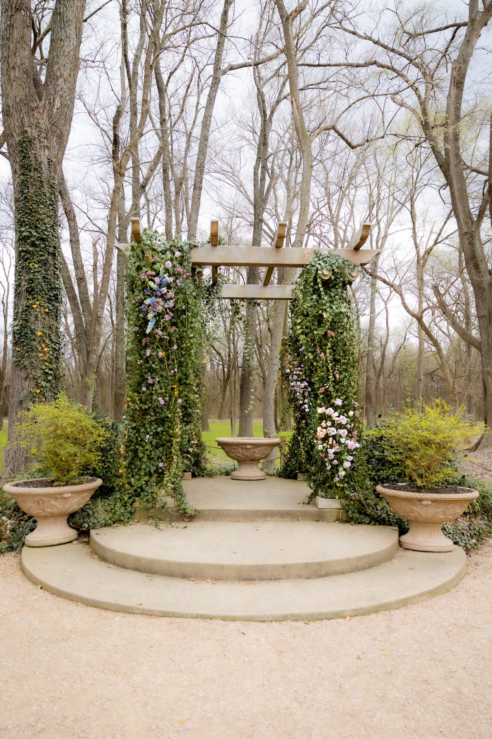 Pastel pergola altar at The Springs Waxahachie with terracotta urns and cascading florals by B.blumen
