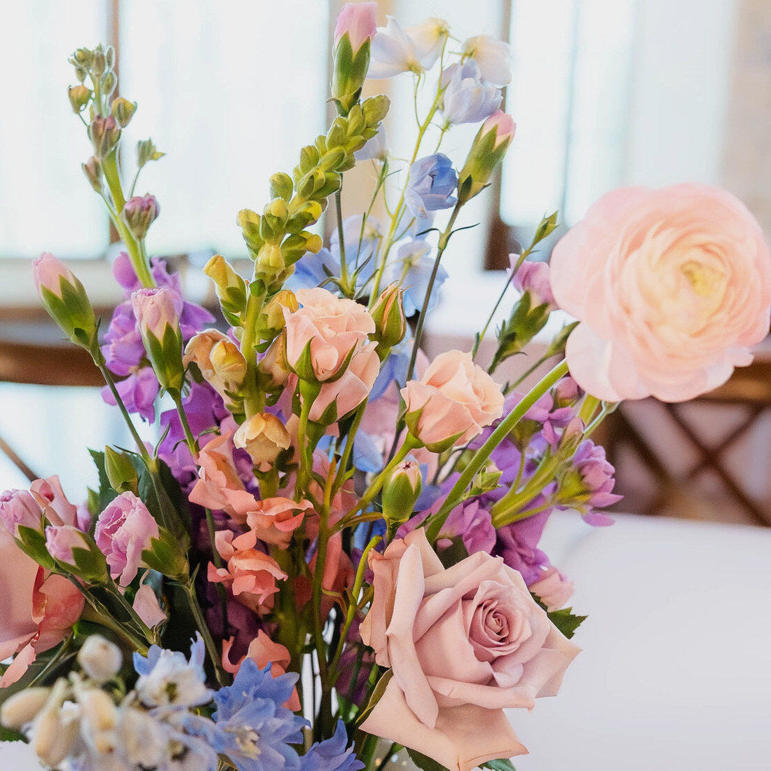 Vibrant reception centerpiece at The Springs Waxahachie on a table with a blue runner and candle taper by B.blumen