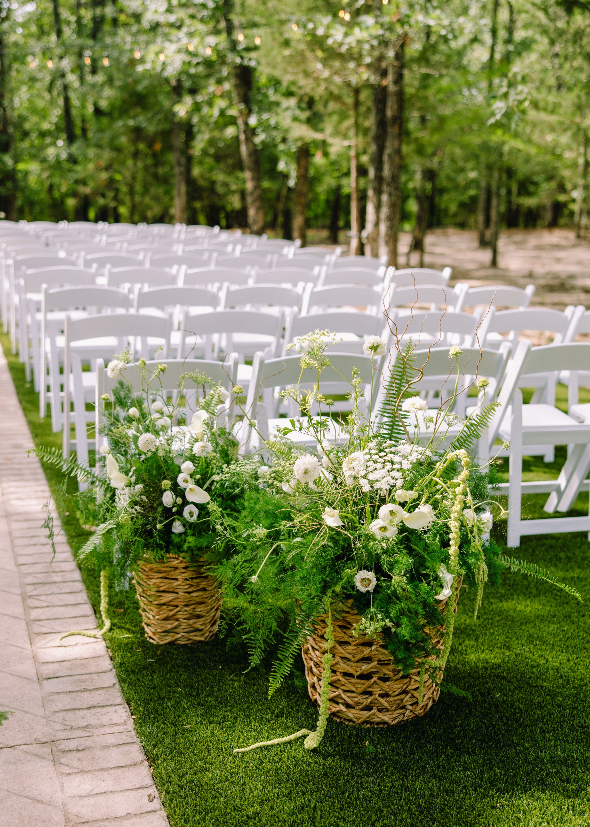 White and green outdoor ceremony aisle at The White Sparrow with woven-basket arrangements, by B.blumen