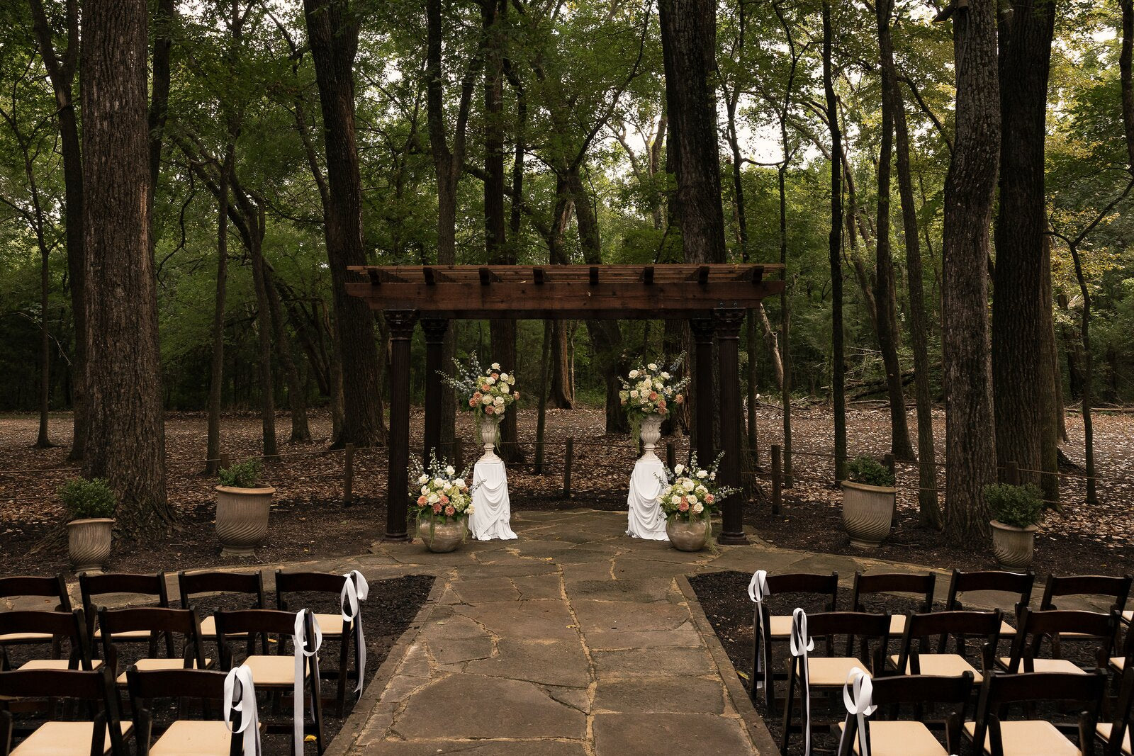 Wide establishing view of The Springs Waxahachie outdoor ceremony space with B.blumen floral installation
