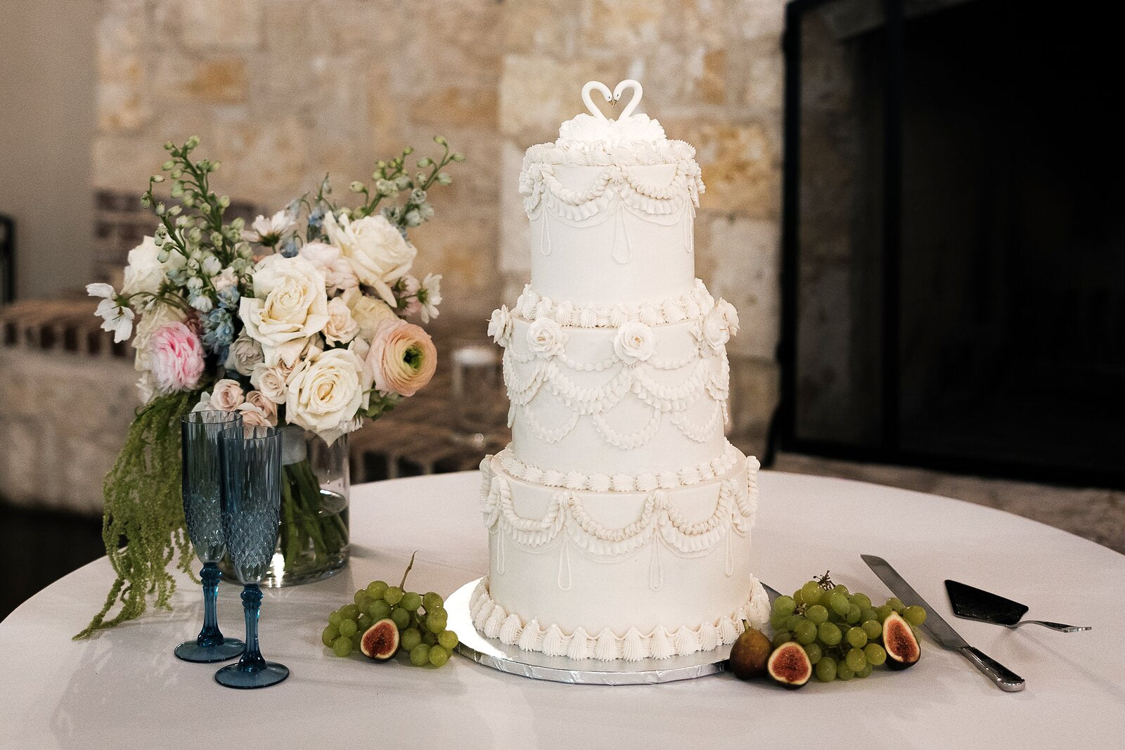 Wedding cake with floral arrangement and figs by B.blumen at The Springs Waxahachie reception