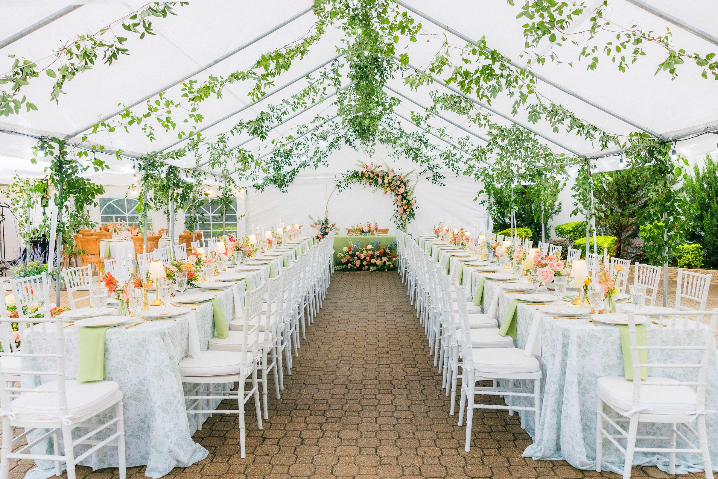 Tented banquet seating under a suspended greenery installation