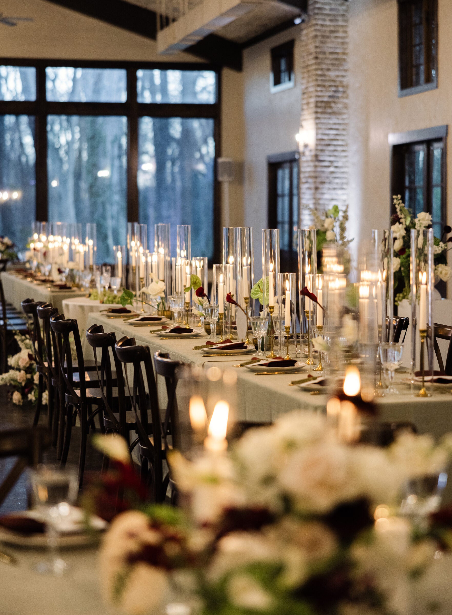 Long candle-lit reception table at The Springs Waxahachie with burgundy and white florals by B.blumen