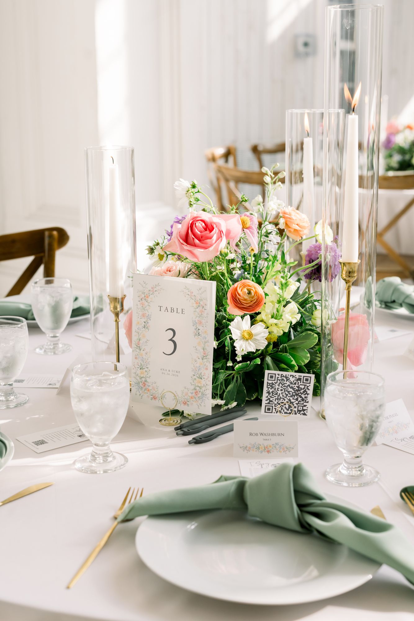 Centerpiece at The White Sparrow in coral, pink, and peach garden roses with trailing greenery, set on a round reception table, by B.blumen