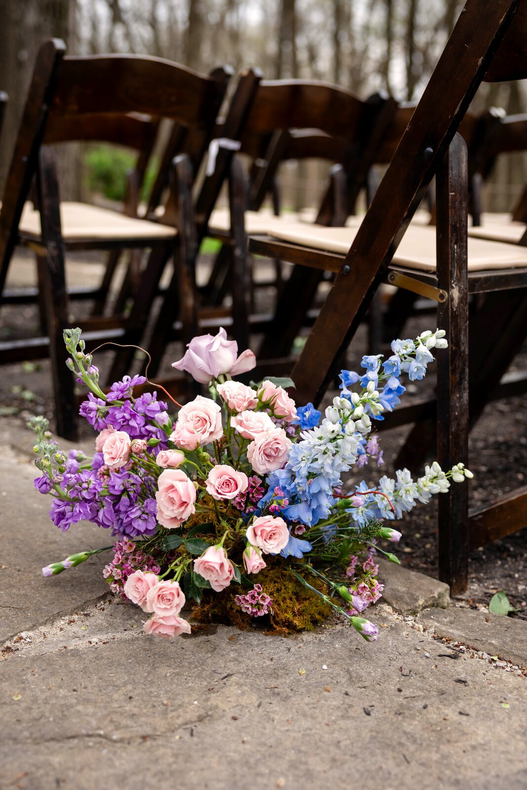 Close detail of an aisle-marker arrangement at The Springs Waxahachie in pink, purple, and blue florals by B.blumen