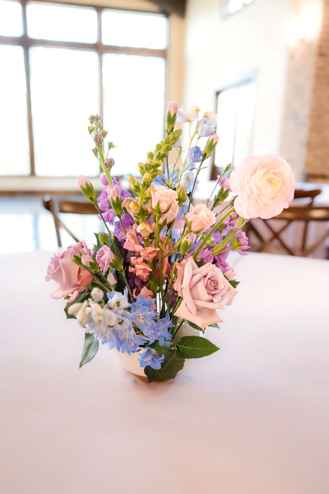 Vibrant reception centerpiece at The Springs Waxahachie on a table with a blue runner and candle taper by B.blumen
